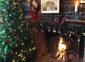 Christmas tree and open fire alight in the hearth.